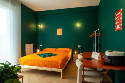 a bedroom with an orange bed and a green wall at MR Suites Bergamo in Seriate