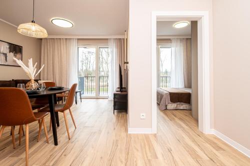 a dining room with a table and a bedroom at Tarasy Bernardyńskie 44 in Kalisz