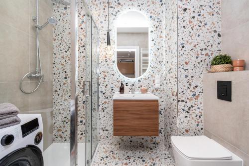 a bathroom with a shower with a sink and a mirror at Tarasy Bernardyńskie 44 in Kalisz