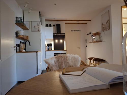 a kitchen and a table with a book on it at Lachmöwe by DeJu -4 Sterne DTV-Klassifizierung- in Norderney