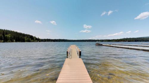 a wooden dock on a lake with a boat at Beth's Lakeside Cabin in McCall