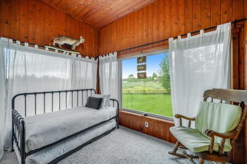 a bedroom with a bed and a chair and a window at Fun w/ Family! Mtn-View Gem w/ Deck in Driggs in Driggs