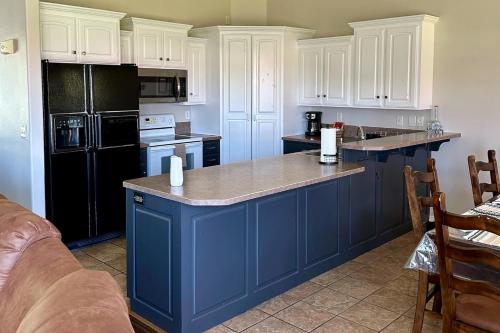 a kitchen with white cabinets and a blue island at Hike, Golf & Explore: Driggs Home w/ Patio & Grill in Driggs