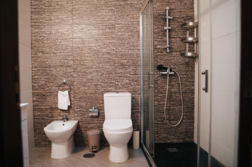 a bathroom with a toilet and a shower at Casa Magenta - Alojamento Local in Trofa