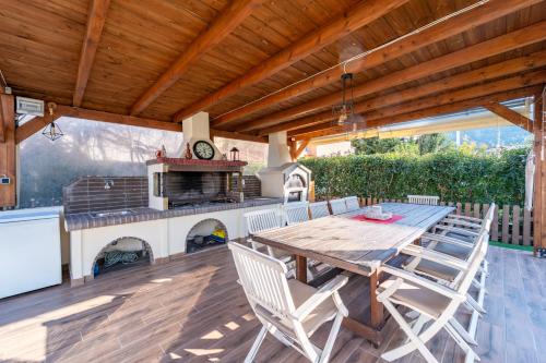 a wooden table and chairs on a patio with a stove at Filerimos Dream Villa in Ialysos