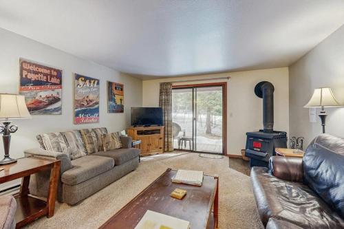 a living room with a couch and a stove at Golf Course Retreat - Pool Access Lake Views in McCall