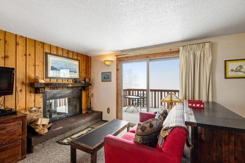 a living room with a red couch and a fireplace at Mountain Condo Ski Access & Sunset Deck in Boise
