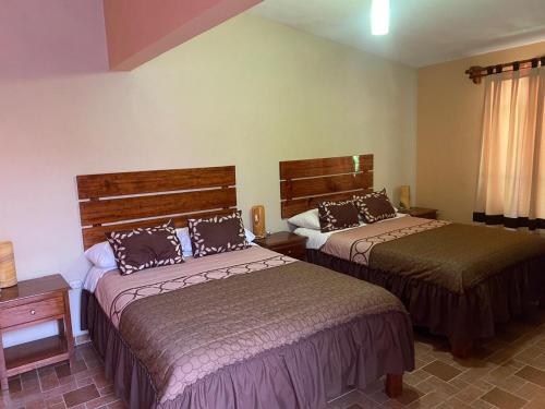 a hotel room with two beds in a room at Casa Amelia Hotel & Boutique in Zacatlán
