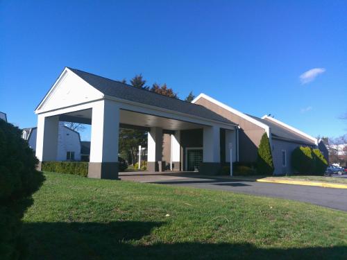 a large white building with a garage at Carradoc Hall Hotel & Conference Center by The Red Collection in Leesburg