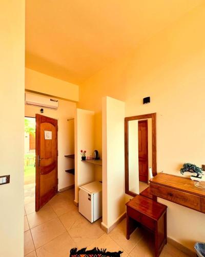 a living room with a table and a refrigerator at Tree House Hotel Dahab in Dahab