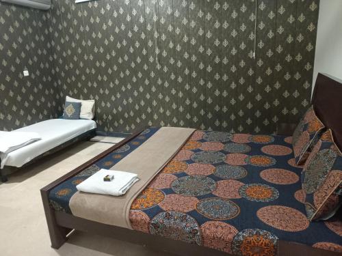 a bedroom with two beds and a wall at The Velmora G-13 in Islamabad