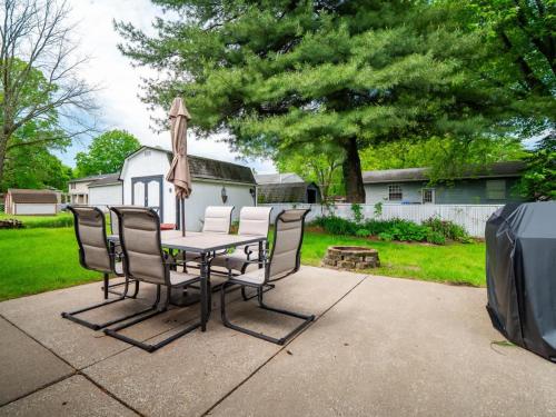 a table with chairs and an umbrella and a tv at Beautiful Ranch with Outdoor Patio and Room for 6 in Munroe Falls