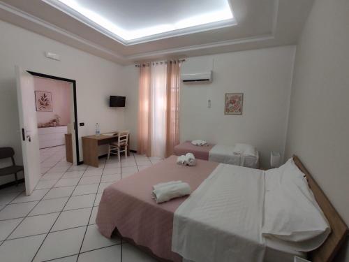 a bedroom with two beds and a desk and a window at Angolo Lamia Sicily Apartment in Partinico