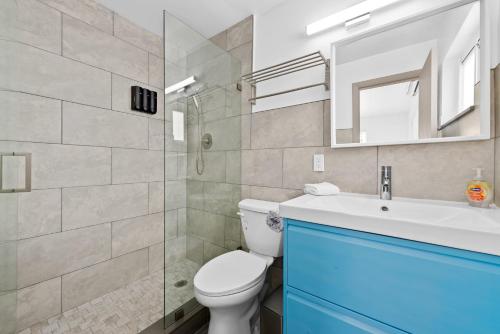 a bathroom with a toilet and a sink and a mirror at Private Studio w Pool Patio steps to the Beach in Deerfield Beach