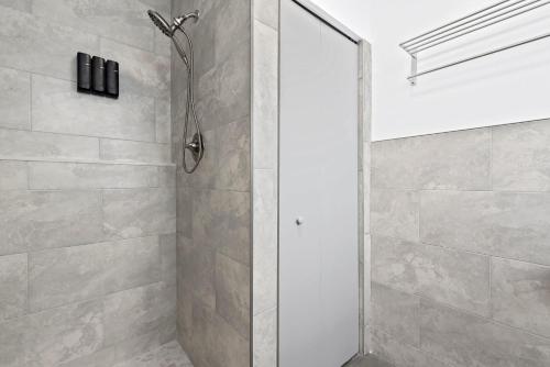 a shower with a glass door in a bathroom at Private modern studio w pool - Steps to the beach in Deerfield Beach