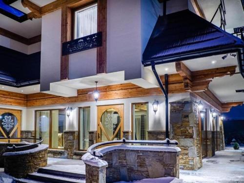 a house with a stone fireplace in the snow at Golden Apartments - Villa Taternik - Tatry View in Zakopane