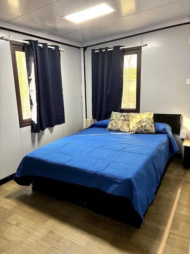 a bedroom with a bed with blue sheets and two pillows at Casa Bonassola, Barra de Navidad in Barra de Navidad