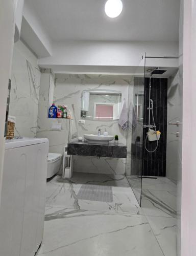 a white bathroom with a sink and a toilet at White Ribbon Prizren in Prizren