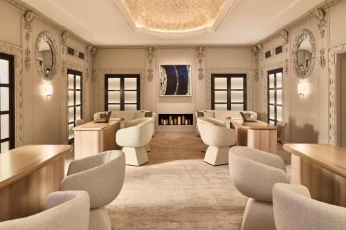 ein Salon mit weißen Stühlen, Tischen und Fenstern in der Unterkunft The Berkeley, Maybourne in London