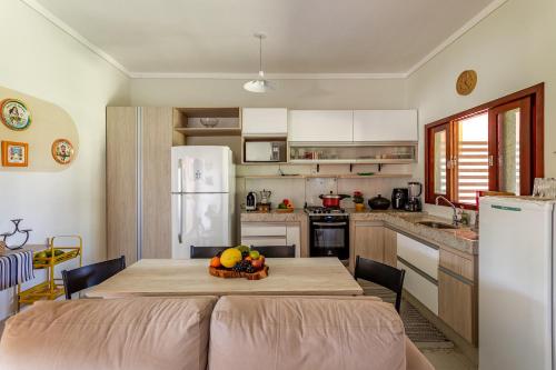 a kitchen with a table with a bowl of fruit on it at Refúgio Gostoso in São Miguel do Gostoso