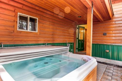 a jacuzzi tub in a log cabin at Rustic-Modern Cabin with Hot Tub Access in McCall
