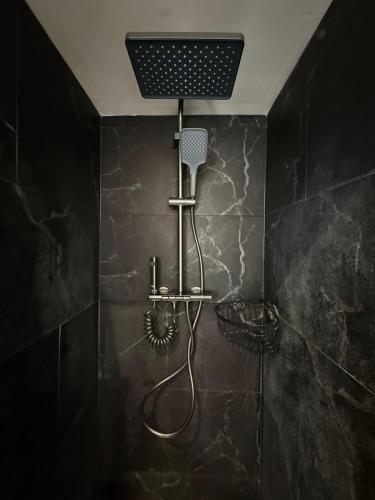 a shower in a bathroom with a black tiled wall at Salabardoa Ea in Ea
