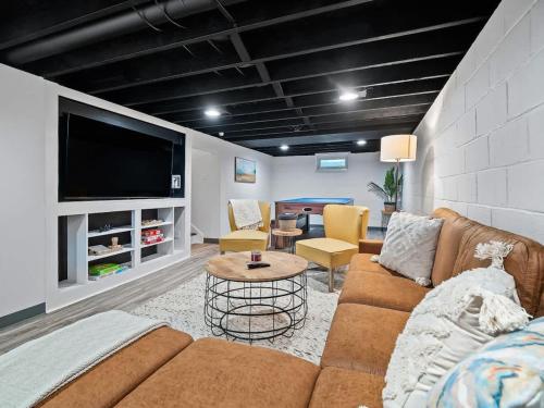 a living room with a couch and a flat screen tv at Renovated Cottage - Game Room - Fire Pit - Sleeps 8 in Moreland Hills