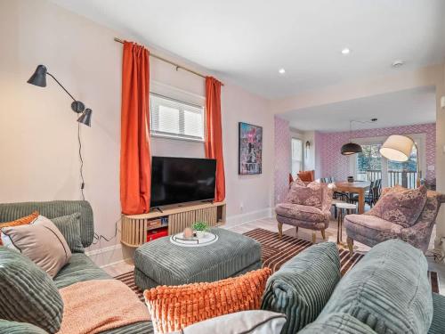 a living room with couches and a flat screen tv at Cleveland Escape - Hot Tub - Karaoke Machine - Sleeps 12 in Cleveland