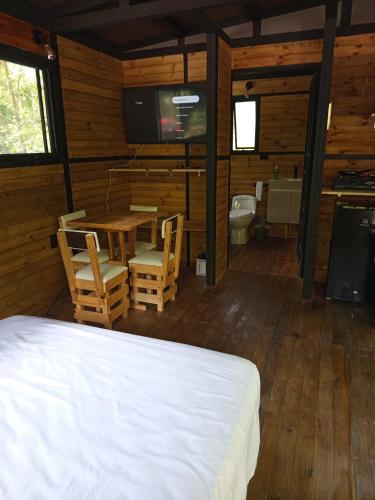 a bedroom with a bed and a table and chairs at Glamping las palmas in Nimaima