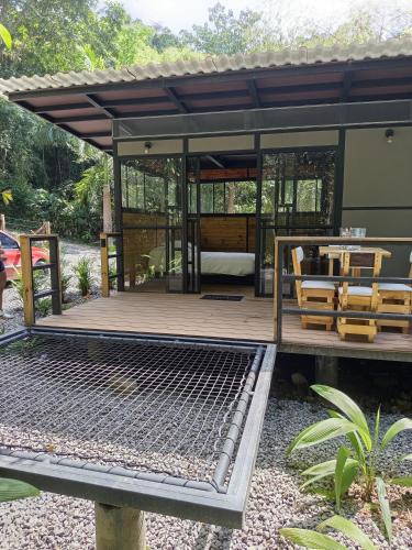 a house with a deck with a table and chairs at Glamping las palmas in Nimaima