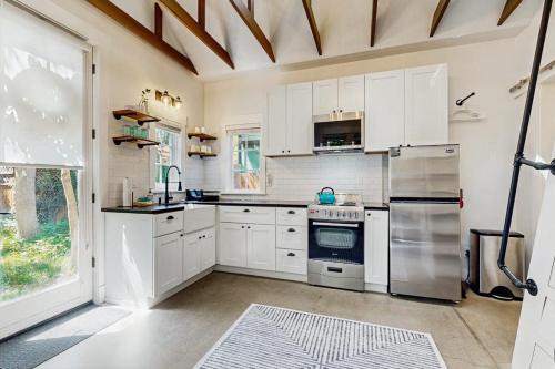a kitchen with white cabinets and stainless steel appliances at Charming Tiny Home in Boise's North End in Boise