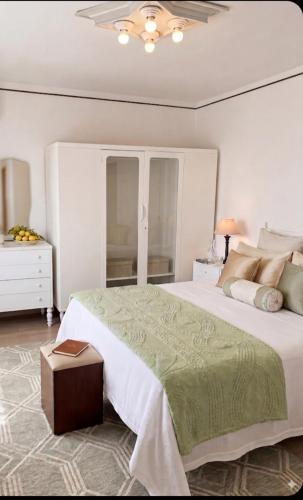 a bedroom with a large bed with a green blanket at La dimora di nonna Giuseppa in Pachino