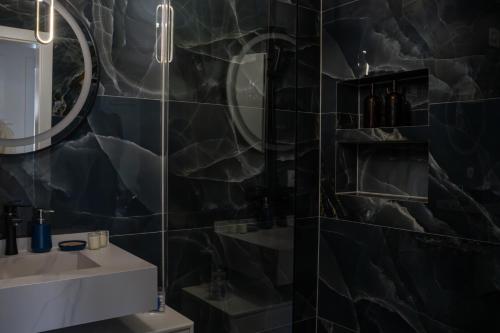 a bathroom with a sink and a mirror at Inviti Apartments in Gjakove