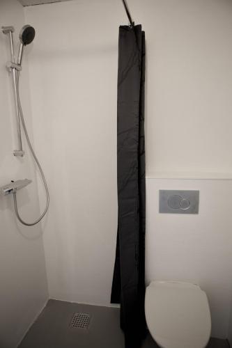 a bathroom with a shower with a chair and a microphone at Captains Room - Havborg in Hvannasund