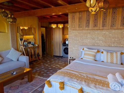 a bedroom with a large bed and a couch at studio Azur rooftop with ocean view terrace privé in Essaouira