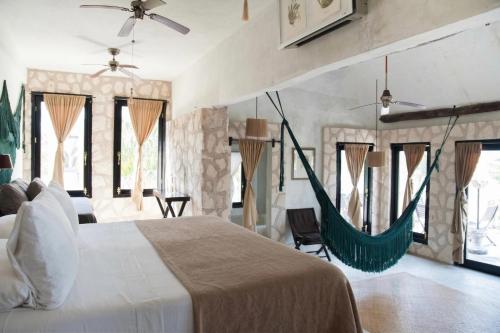 a bedroom with a bed and a hammock in it at Coqui Coqui Papholchac Coba Residence & Spa in Coba