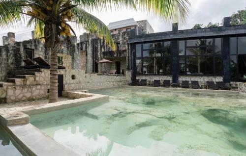 a swimming pool at a villa with palm trees at Coqui Coqui Papholchac Coba Residence & Spa in Coba