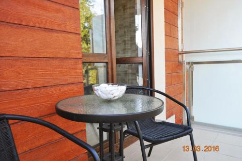 a black table and chair on a balcony at Apartament Morska Ostoja in Krynica Morska