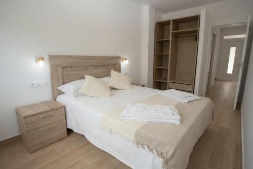a bedroom with a bed with two towels on it at Apartamentos Turísticos El Cholo in Fisterra
