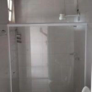 a white bathroom with a shower and a sink at Pousada Bromelias in Imbassai