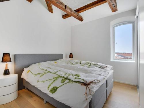 a white bedroom with a large bed and a window at Two-Story Loft with Large Terrace in Løkken