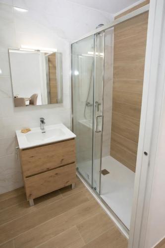 a bathroom with a shower and a white sink at Apartamentos Turísticos El Cholo in Fisterra