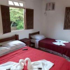 a room with two beds with swans on them at Pousada Bromelias in Imbassai