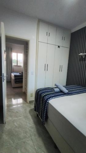 a bedroom with a bed with a blue and white blanket at Dois quartos mobiliado próximo a praia in Vila Velha