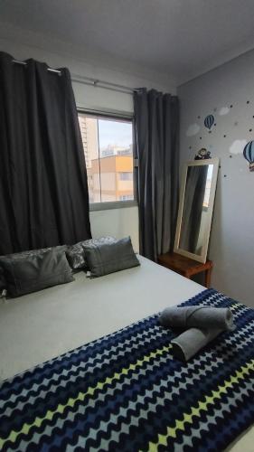 a bedroom with a bed with a checkered blanket on it at Dois quartos mobiliado próximo a praia in Vila Velha
