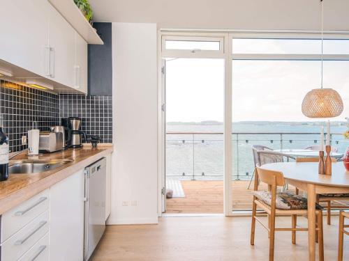 a kitchen with a table and a view of the ocean at 4 person holiday home in Hejls-By Traum in Hejls