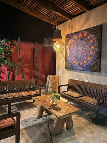 a room with benches and a table and a painting at Aqua Viva in Tulum