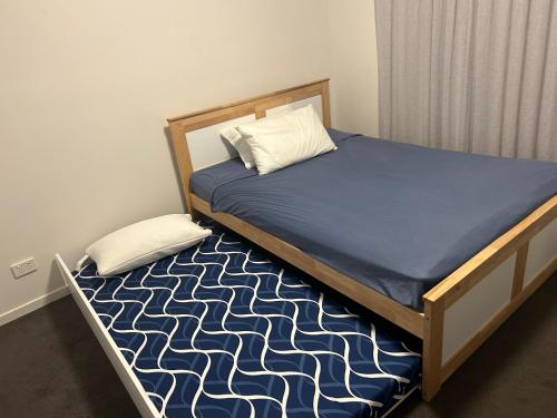 a bed in a bedroom with a blue mattress and pillow at Sand Dunes Resort Stunning Beachfront Apartment in Mudjimba