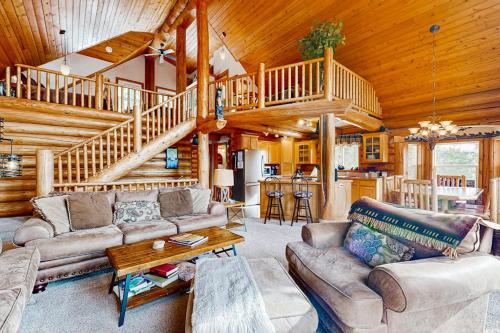 a living room with couches and a staircase in a cabin at Cascade Lakeview Log Cabin in Cascade