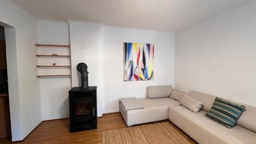 a living room with a white couch and a stove at Urlaub in den Bergen in Puchberg am Schneeberg